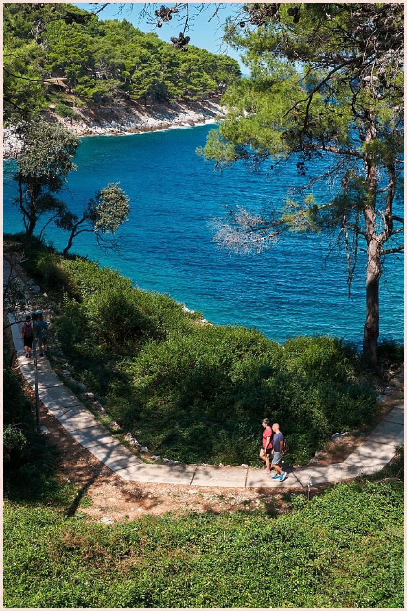 Two poeople walking along the promenade by the beach with beautiful scenery at Ljubicic Tennis Academy in Veli Lošinj Croatia